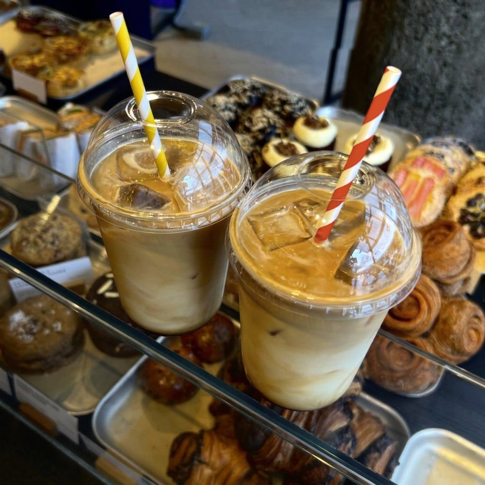 easipac clear dome lids with straw holes and paper straws, iced coffees on a bakery counter