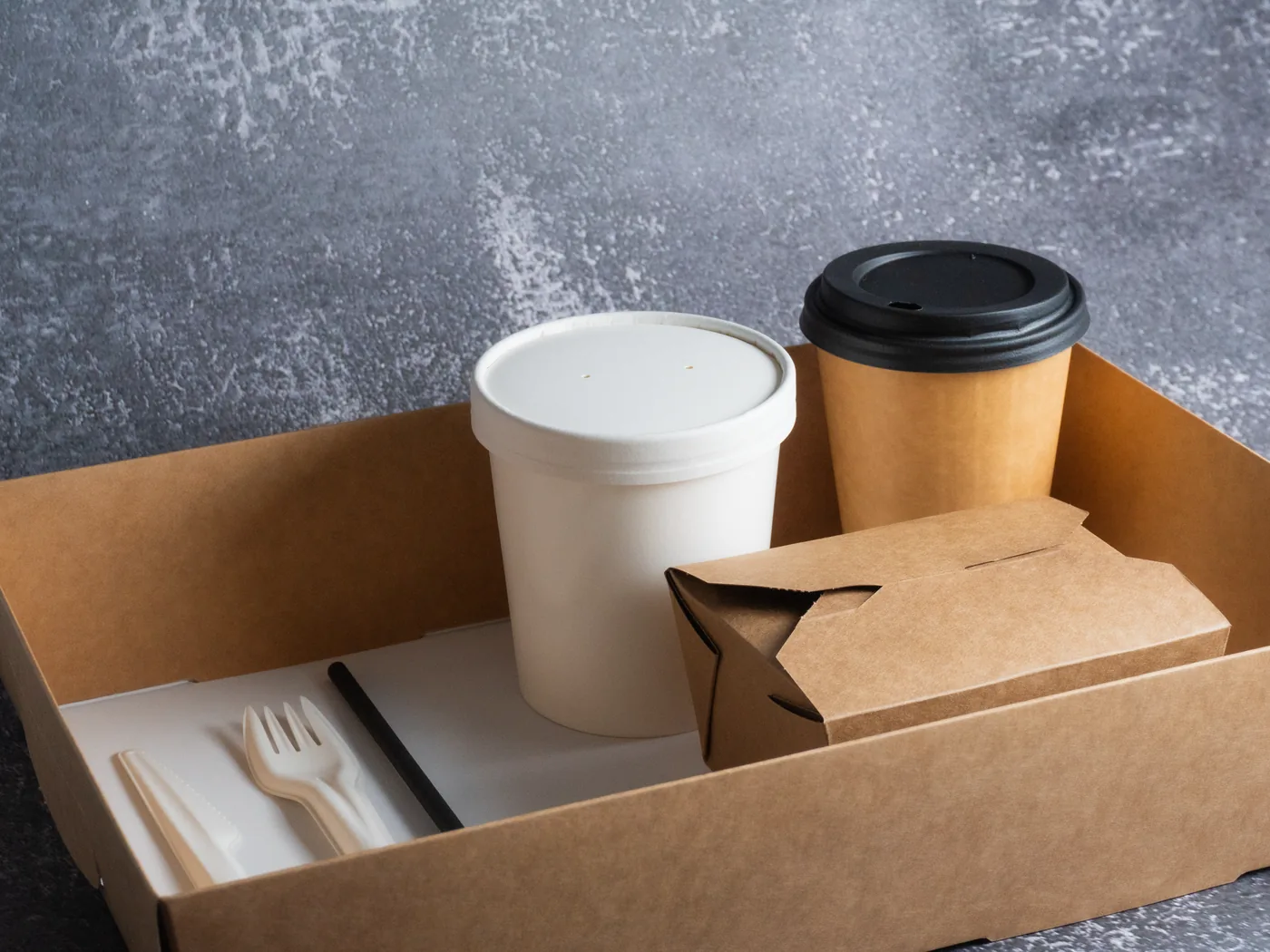A kraft tray holding an easipac hot cup, soup cup, food box, napkin and wooden cutlery